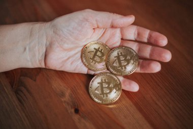 Bitcoin coins in hand, the concept of mining and unstable earnings, finance concept