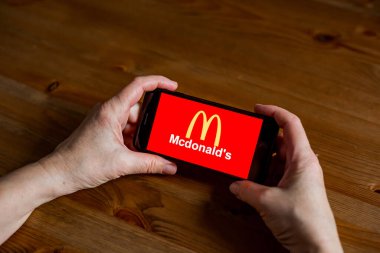 McDonald logo uygulama ekranını cep telefonunda çevrimiçi perakende hizmeti, eller