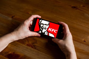 Cep telefonundaki Kfc logo uygulama ekranını çevrimiçi perakende hizmeti, eller