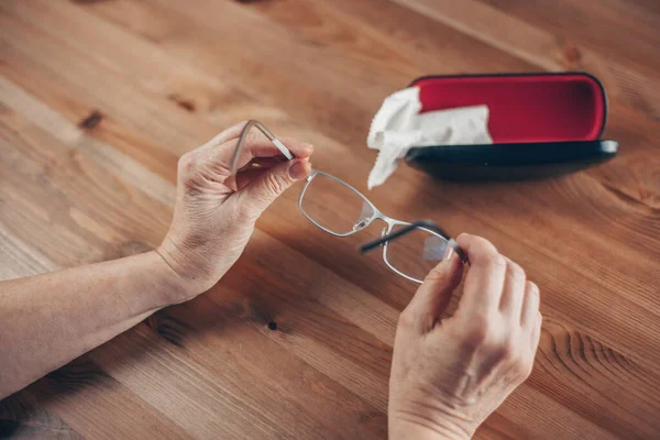 Špinavé brýle, žena ruku důkladně čistí brýle látkou, — Stock fotografie