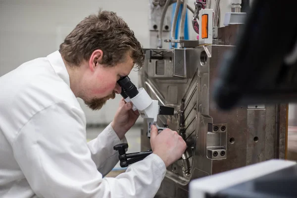 Ingeniero de calidad comprueba las deficiencias en el molde de inyección por un microscopio, concepto industrial —  Fotos de Stock