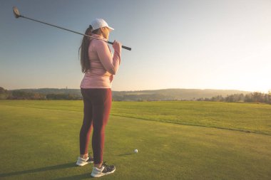 Golf sahasındaki profesyonel kadın golfçü golf oynamaya hazır.