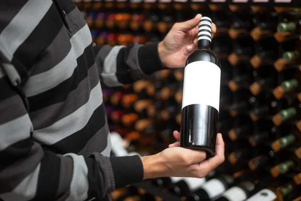 거대 한 와인바에 붉은 코르크 와인을 들고 사람들의 손을 꼭 잡고 있는 남자들의 손을 가까이 하며 와인을 저장하는 컨셉트는 — 스톡 사진