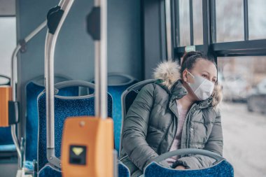 Coronavirus covid 2019 kadın solunum maskeli toplu taşıma otobüsüyle seyahat ediyor.