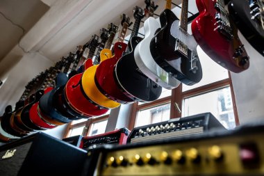 Profesyonel elektro gitarların büyük bir arenası bir mağazada arka arkaya, müzik aletleriyle örtülmüş.