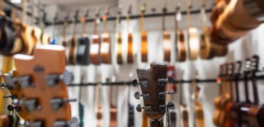 Büyük bir müzik dükkanında, enstrüman dükkanında, enstrüman konseptinde üst üste sıralanmış klasik gitarı kapat