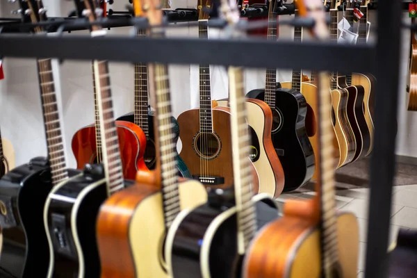Close up of classic guitar drapped in a row in a huge musical shop, instrument shop, instrument concept — Stock Photo, Image