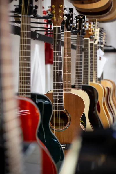 Close up of classic guitar drapped in a row in a huge musical shop, instrument shop, instrument concept — Stock Photo, Image