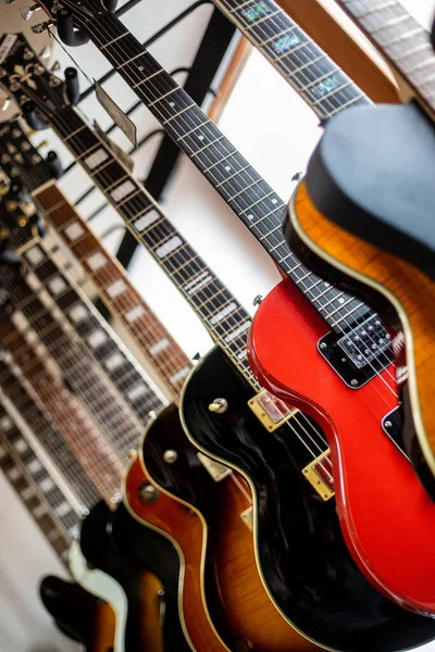 Close up of professional electric guitar drapped in a row in a huge instrument, musical shop, instrument concept — Stock Photo, Image