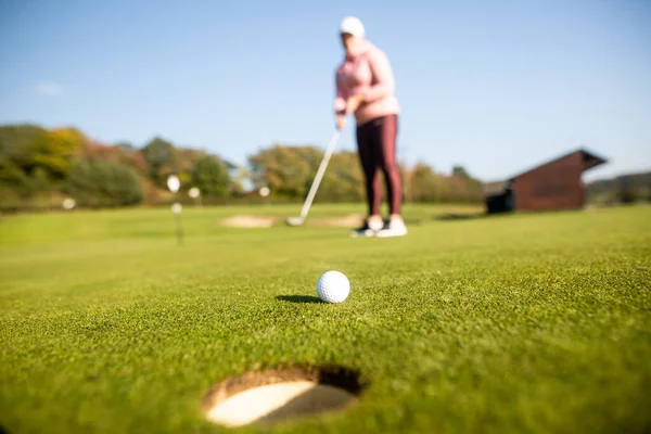 Feminino mendigo jogador de golfe jogando golfe no campo de treinamento, conceito de esporte — Fotografia de Stock