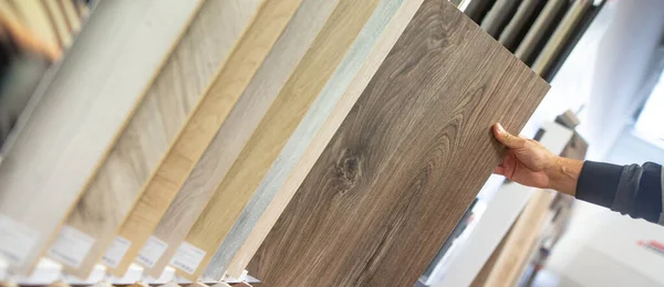Mężczyzna wybierający odpowiedni kolor i materiał drewnianej podłogi do swojego nowego mieszkania w studio podłogowym, wyposażanie gospodarstw domowych — Zdjęcie stockowe