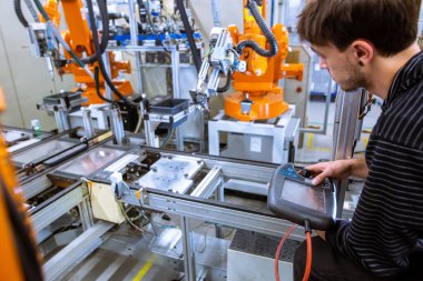 Mühendis akıllı fabrikada otomatik robot silahları kuruyor, otomotiv endüstrisi, endüstriyel konsept