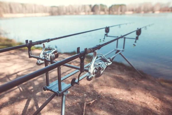 Two cast fishing rods on the rack by the lake, ready for fishing, carpfishing, angling, sport concept