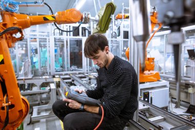 Otomotiv akıllı fabrikada otomatik robot silahları programlayan programcı, endüstriyel konsept