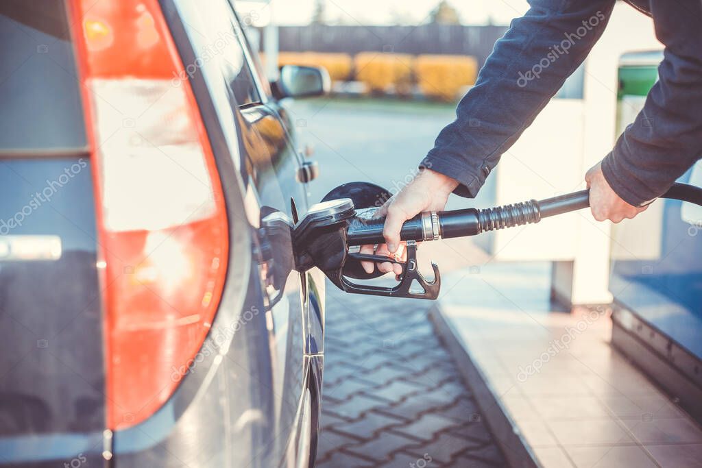 Man refueling a car during low fuel rates, fuel prices, transport concept