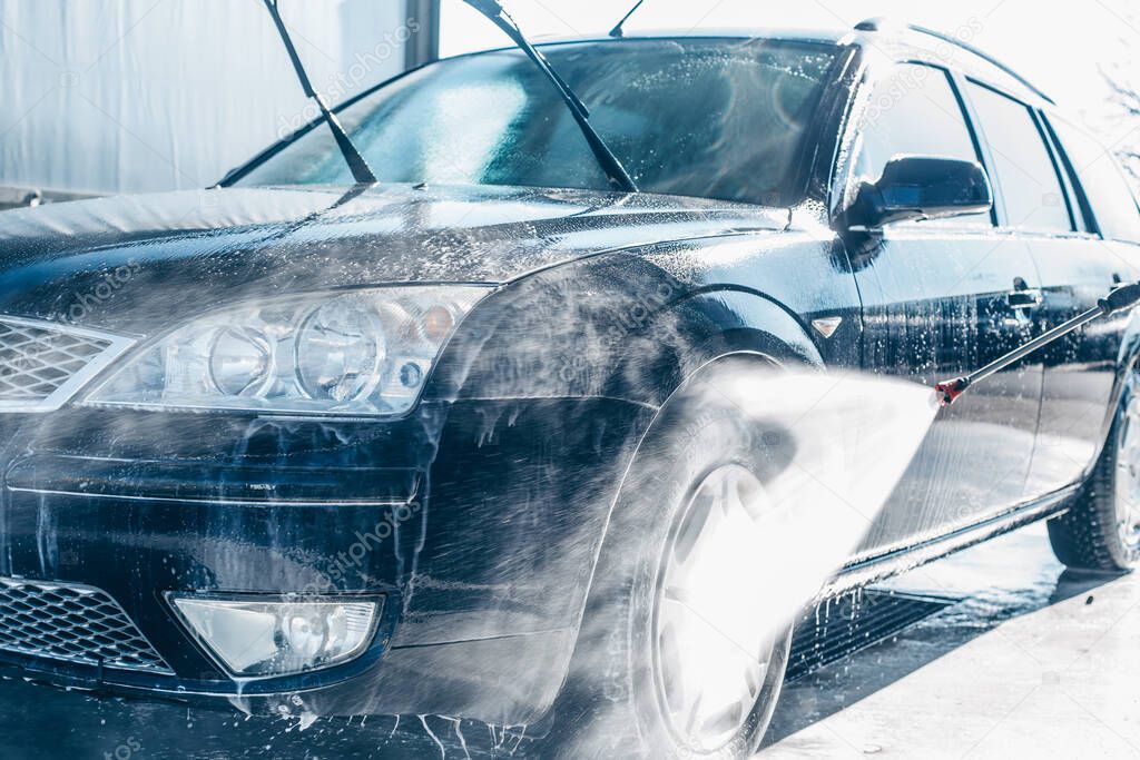 Manual car washing, cleaning using high pressure water in car wash, purifying concept