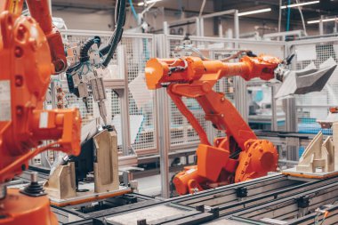 Otomotiv endüstrisindeki otomatik robot silahlarının kapatılması, bir araba için fabrika yapımı farlar, endüstriyel konsept