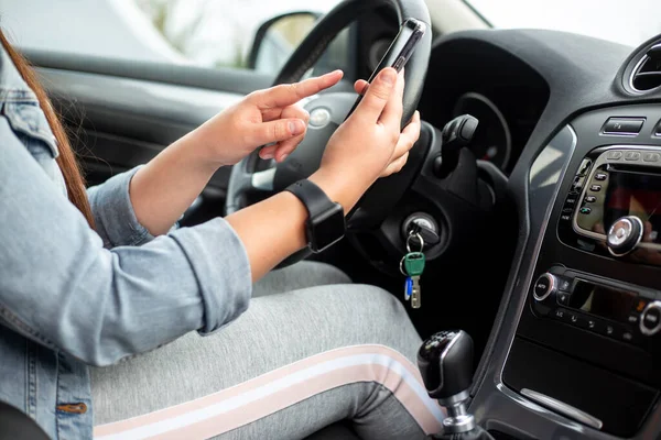 Conductora usando un móvil, teléfono inteligente durante la conducción de su coche, concepto peligroso —  Fotos de Stock