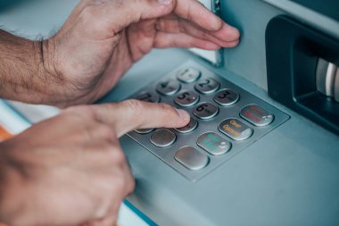 Adamın biri ATM 'ye kredi kartı için şifre giriyor, para çekiyor, finans kavramını kullanıyor.