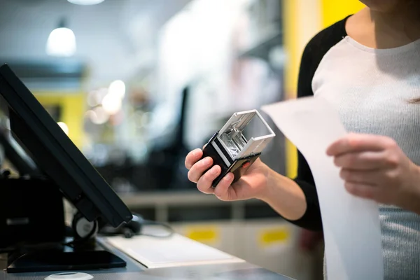 Vendedora, shopgirl dando um selo em um recibo, fatura para um cliente, tempo de vendas, período de desconto, conceito de finanças — Fotografia de Stock