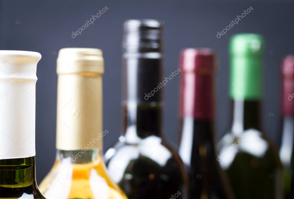 Close up of wine bottles in a row isolated on a gray background, bottles of wine 