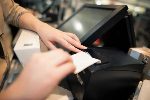 Mulher jovem imprimindo alguma fatura, recibo de um cliente no enorme centro comercial, conceito de finanças — Fotografia de Stock