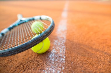 Tenis raketi ve topları yakından izle kil tenis kortunda, eğlence sporu, boş zaman