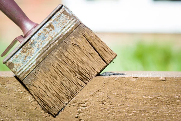 Spazzola rossa sporca che giace su un pezzo di legno dopo il lavoro, paesaggio, giardino, concetto fai da te — Foto Stock