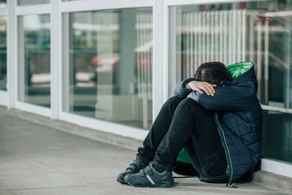 Menino ou criança sentado sozinho no chão em frente à escola depois de sofrer um ato de bullying — Fotografia de Stock