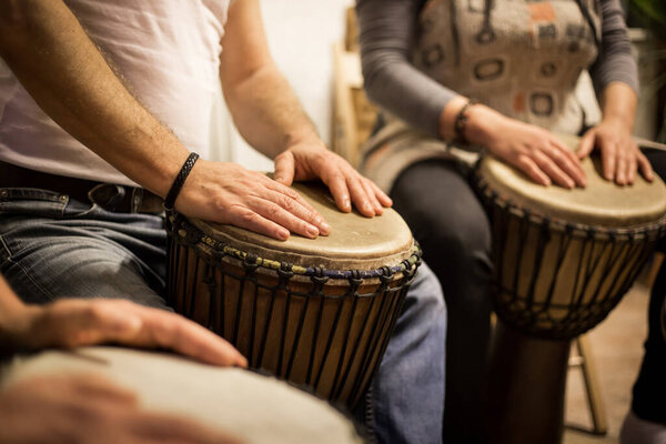 Close up of hands on african drums, drumming for a music therapy, therapy by drums