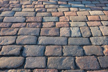 Güneş tarafından aydınlatılan bir taş kaldırım parçası. Farklı renkte taşların dikdörtgen şekli vardır. Geçmişi. Doku.