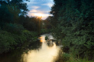 Batan güneşin ışınları nehirde