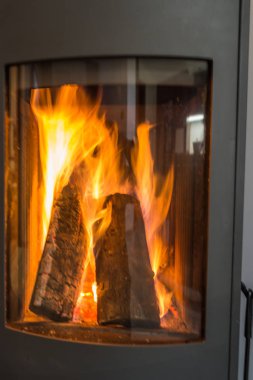 Şöminede alevler var, camdan görülüyor..