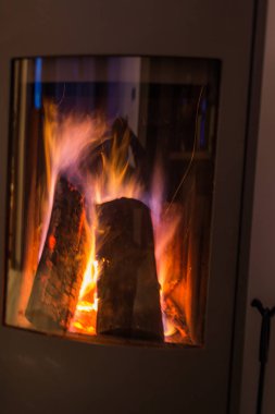 Şöminede alevler var, camdan görülüyor..