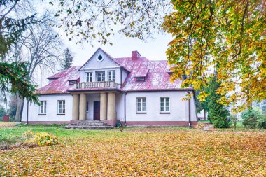 Historic palace surrounded by autumn park, central Poland.