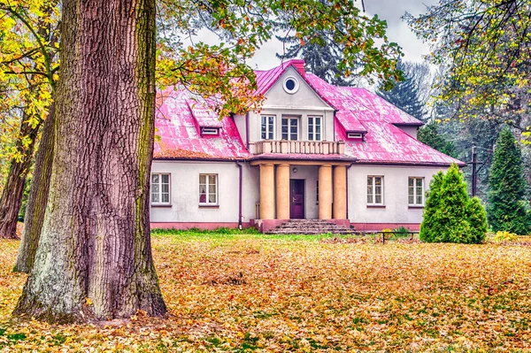 Historic palace surrounded by autumn park, central Poland.