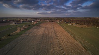 Polonya köyü ve yakındaki tarlalar batan güneşle aydınlandı..