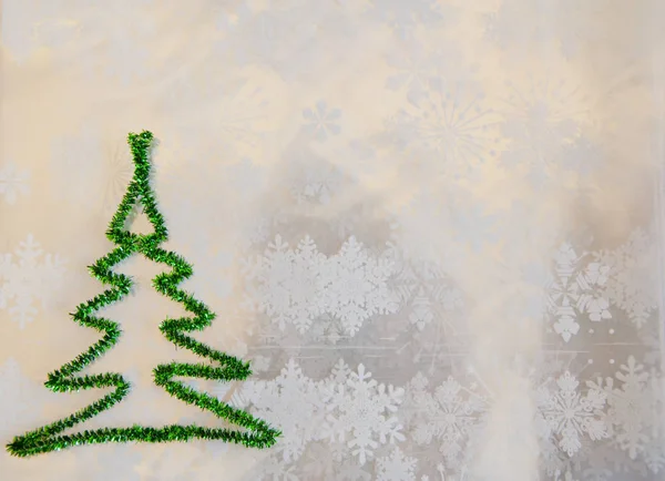 Espacio de copia. árbol de Navidad verde de oropel sobre copos de nieve fondo blanco. clima invernal nevado. Feliz navidad. tiempo de felicitación de Navidad. Deja que nieve. decorar el árbol. tarjeta de felicitación de año nuevo — Foto de Stock