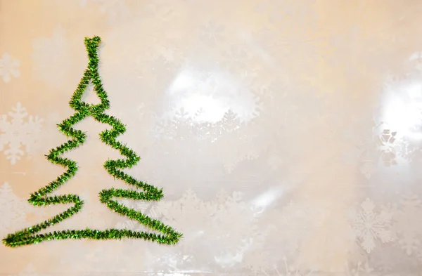 Clima invernal nevado. Feliz navidad. tiempo de felicitación de Navidad. Deja que nieve. decorar el árbol. tarjeta de felicitación de año nuevo. espacio de copia. árbol de Navidad verde de oropel sobre copos de nieve fondo blanco — Foto de Stock