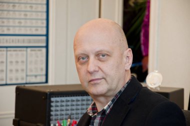 Resmi giyinmiş bir adam. Modern ofiste yönetici takım elbise giyer. Masasında oturan bir adam. Olgun bir iş adamı ya da ajan. Masa başı müşterilere danışmak. Resmi olarak masasında çalışan olgun bir iş adamı.