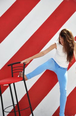 Göz kamaştırıcı kırmızı sandalye. Yeni bir daireye taşınmak. Rahat ve rahat. Mobilyalar. Bar sandalyeli seksi kadın. Mutlu kız rahatla ve eğlen. ev ve ofis iç tasarımı. modern mobilya modası.