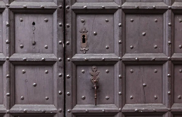 Bakgrund: fragment av en trä dörr - brädor målade i en mörk blå mössa och smidda järn naglar, dörrhandtag, nyckelhålet och fönster med barer. Stil medeltida Europa (Frankrike). — Stockfoto