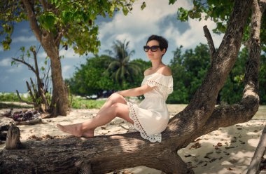 Bir günlük plaj üzerinde oturan bir kız. Maldivler. Adada dinlenmek.