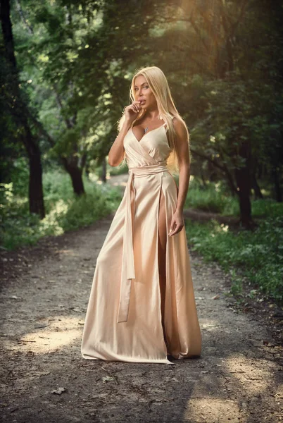 Menina em um vestido longo no parque. Loira. Verão . — Fotografia de Stock