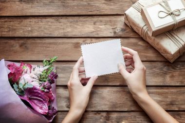 Çiçek buketi, zarf boş hediye etiketi ve ahşap arka plan dekoratif ipi ile güzel el yapımı hediye kutusu (paket)