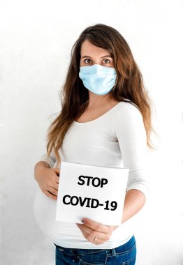 COVID-19 Pandemic Coronavirus Hamile kadın SARS-CoV-2 virüsünü yaymak için yüz maskesi takıyor. Coronavirus hastalığına karşı koruyucu maskeli hamile kız 2019.