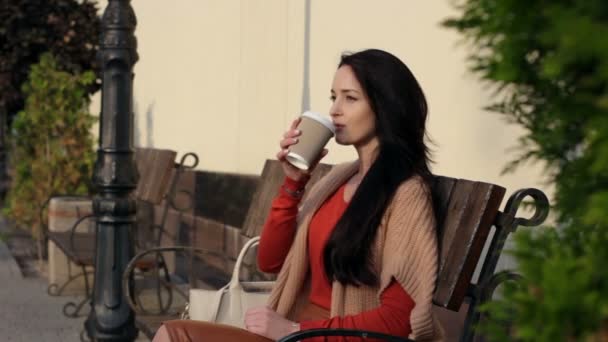 Дівчина п'є каву в парку — стокове відео