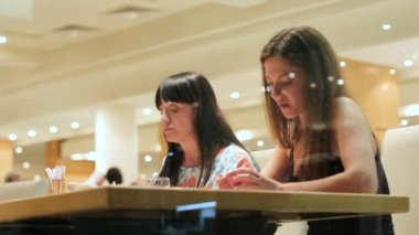 Anne ve kızı restoranda yemek. İki güzel esmer üzerinde büyük bir pencereden görüntüleyin. Yerli halk ile ilişkiler.