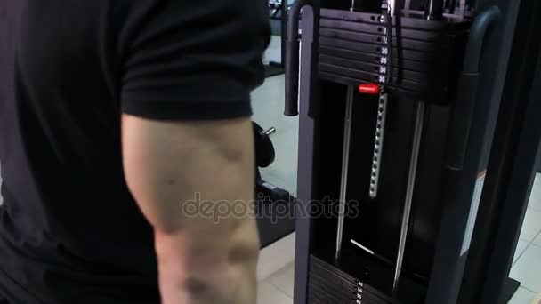 O atleta bombeia os músculos no simulador levantando o grande peso. Triceps masculino close-up . — Vídeo de Stock