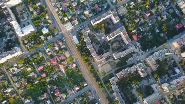 View from a great height to the city in the daytime. The camera turns in a circle. Cars drive on roads. — Stock Video